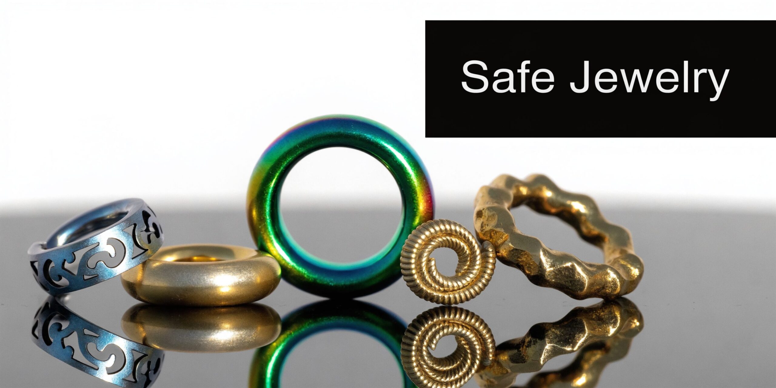 A collection of various stylish body jewelry rings displayed on a reflective surface against white background.