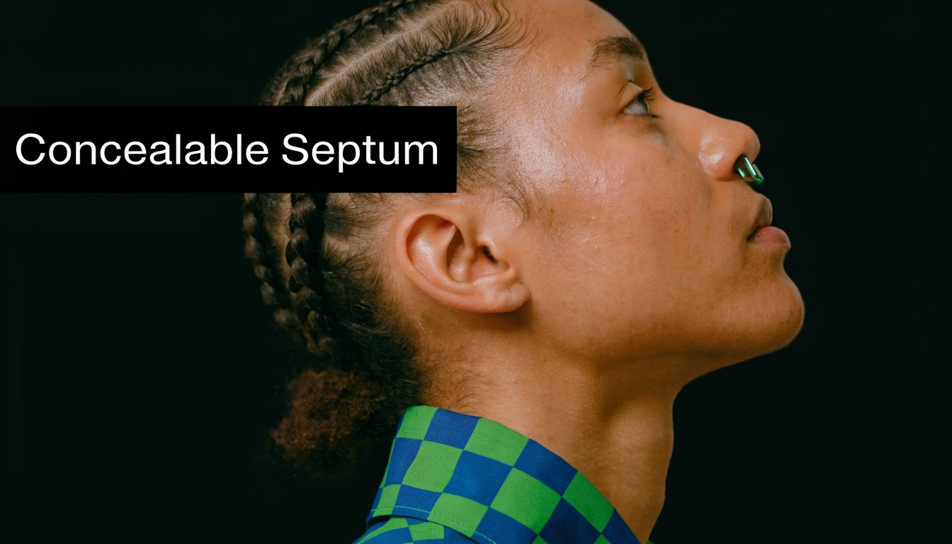 A profile view of a person with braided hair wearing a green concealable septum nose piercing.