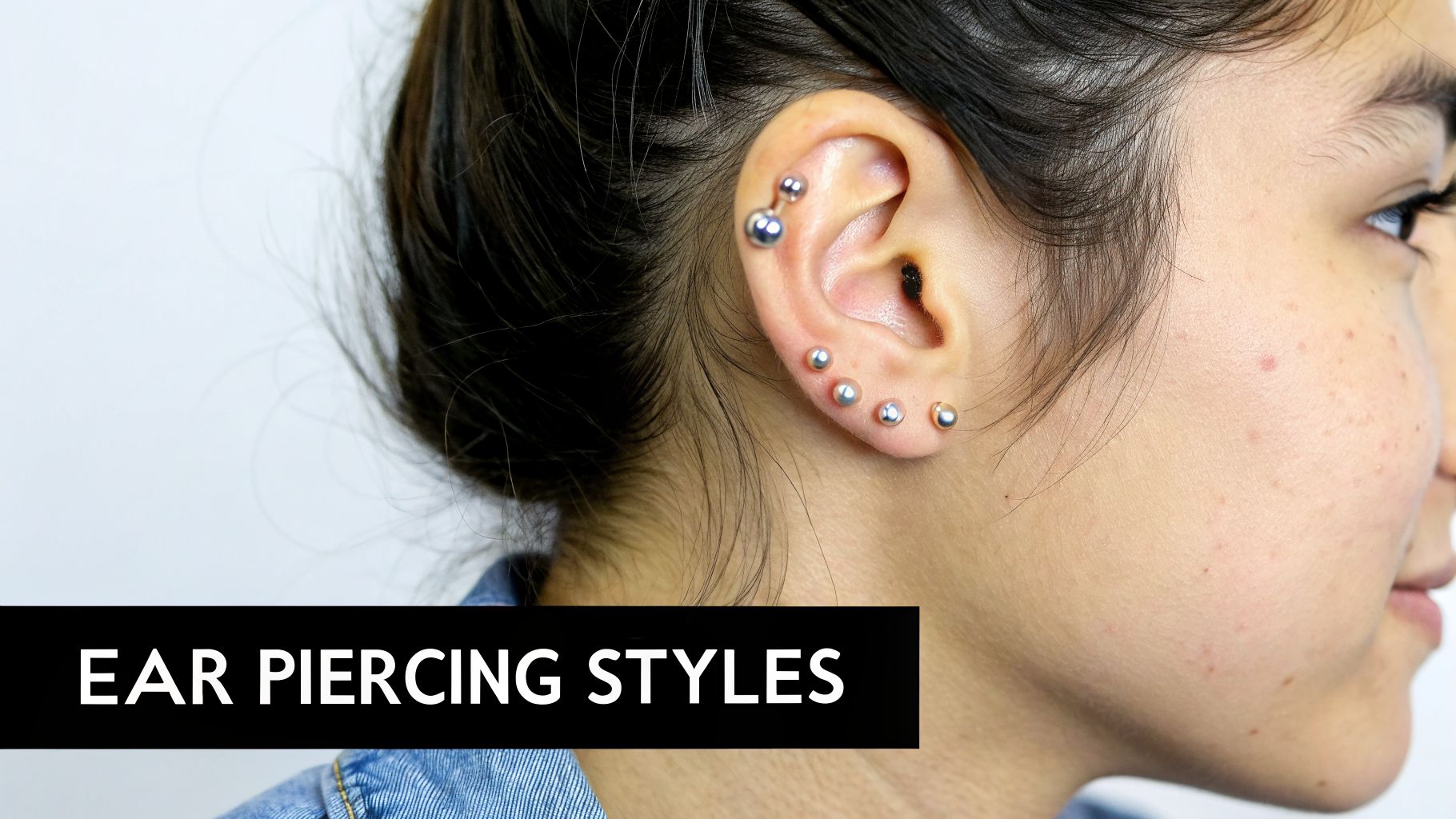 Close-up of a woman's ear featuring multiple silver ball stud piercings, showcasing various styles.