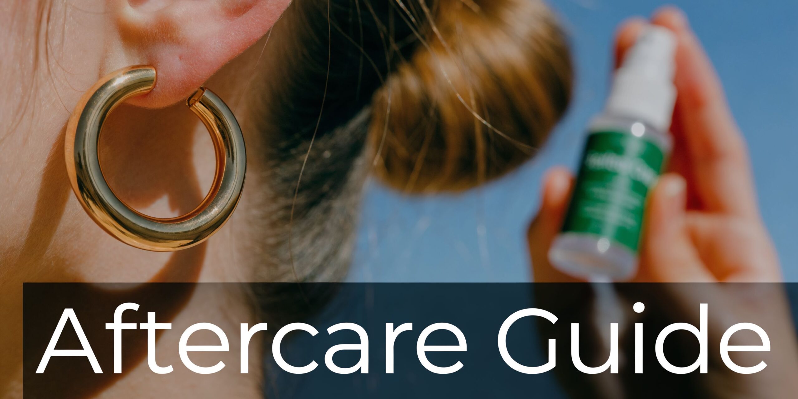 A person holding a piercing aftercare spray bottle near their ear wearing a large gold hoop earring.