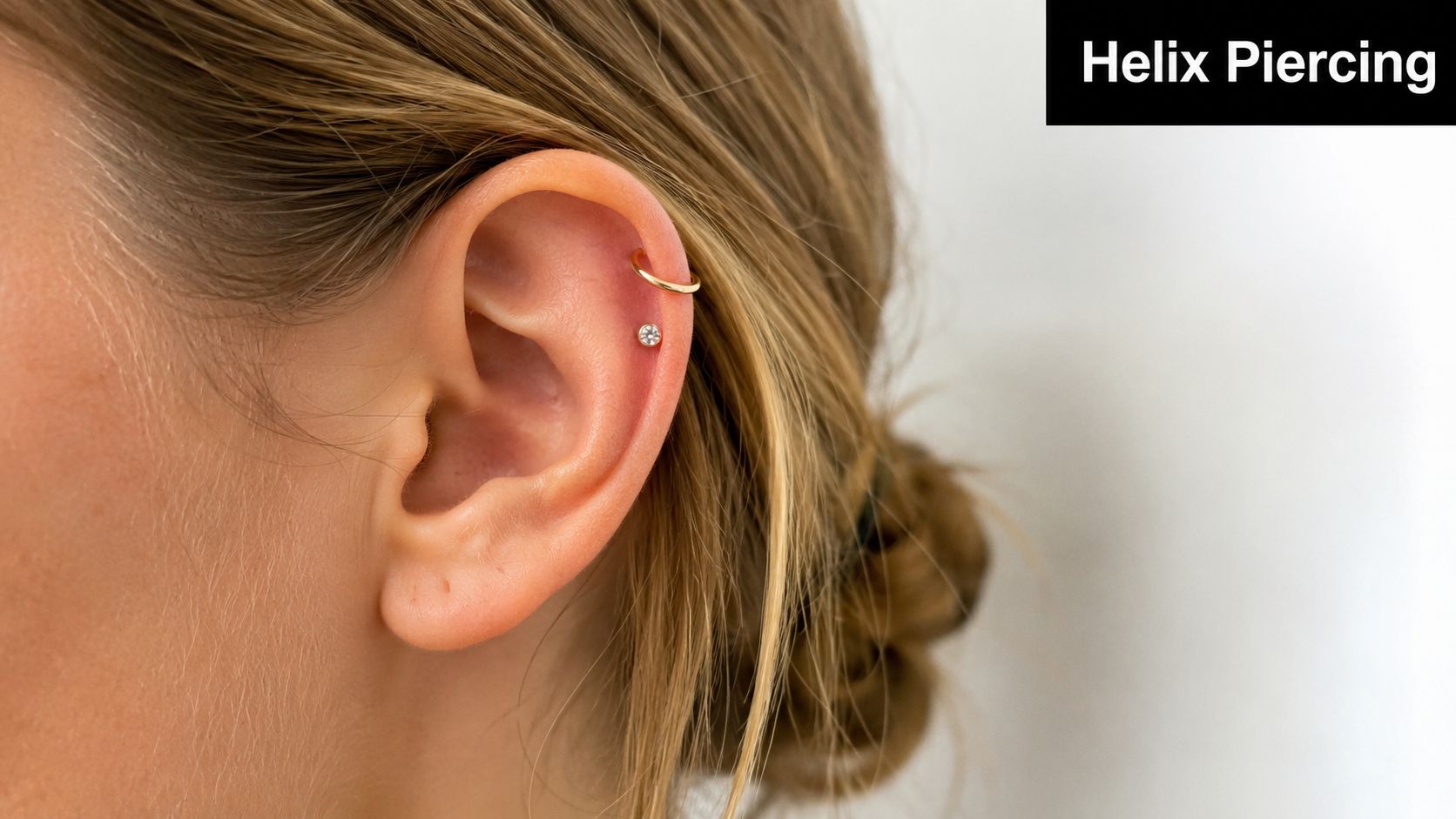 A close-up view of a person's ear showcasing a double helix piercing with a hoop and stud.