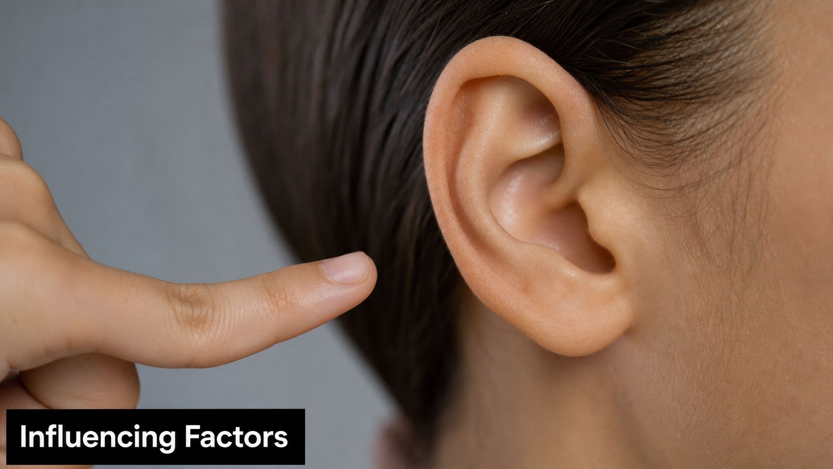 A close-up view of a person's ear with a finger pointing toward the conch area.