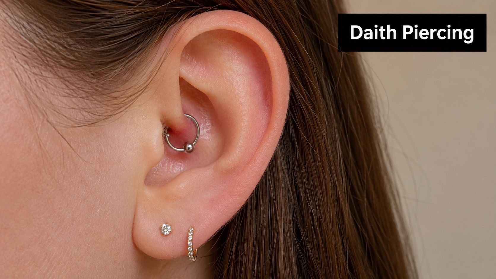 A close-up view of a woman's ear featuring a silver captive bead ring in a daith piercing.