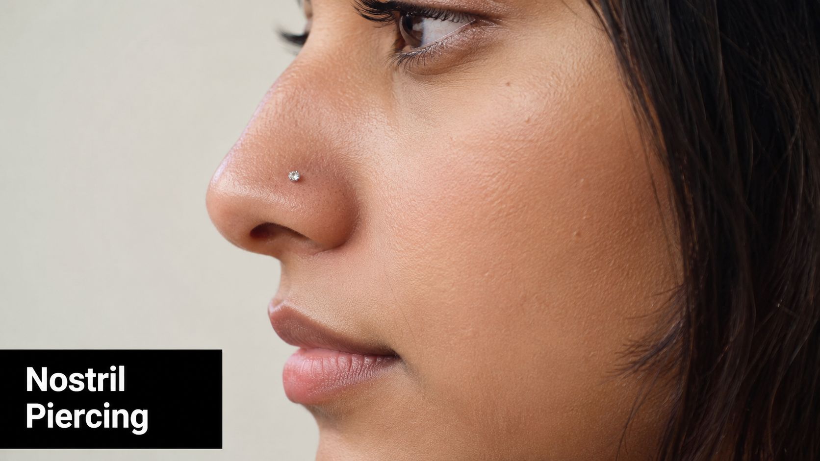 A close-up side profile view of a woman wearing a small sparkling stud nostril piercing.