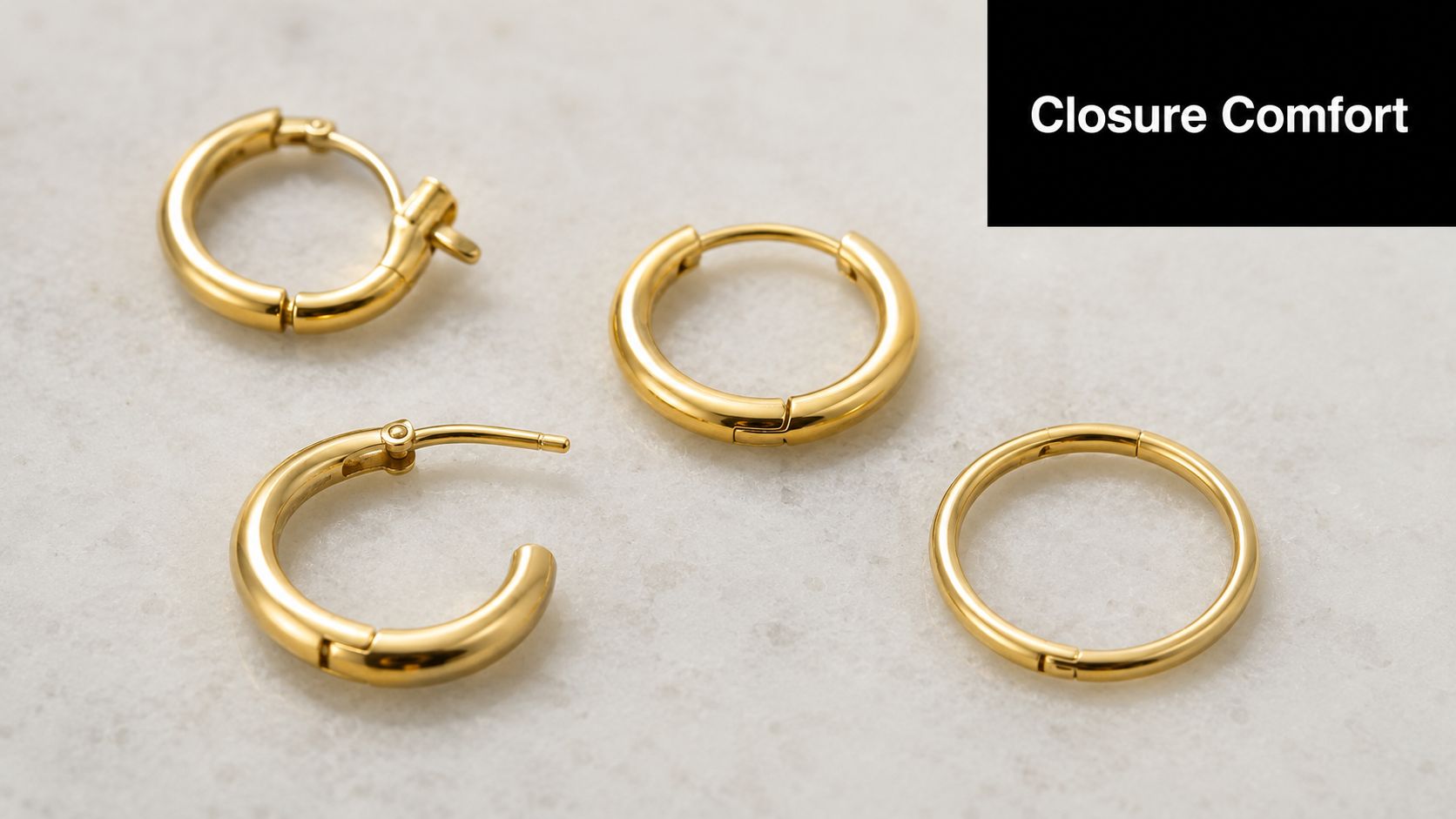 A set of four small gold hoop earrings displayed on a neutral textured surface, showcasing their design.