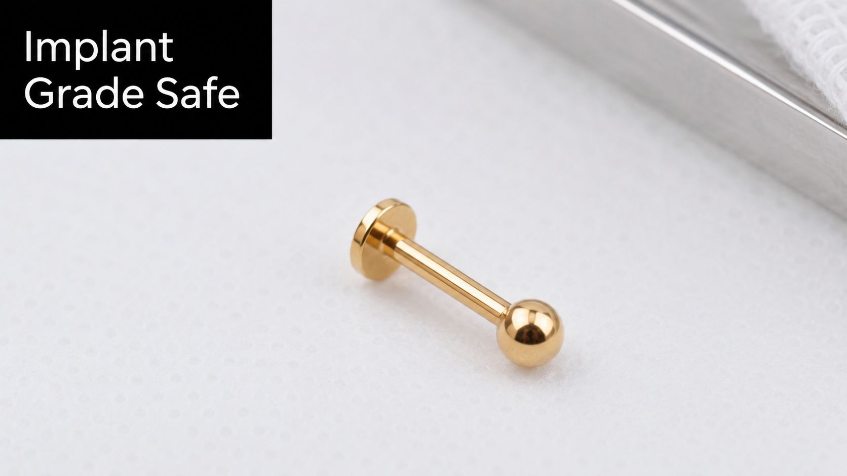 A close-up of a gold labret piercing stud on a white background with implant grade safety text.