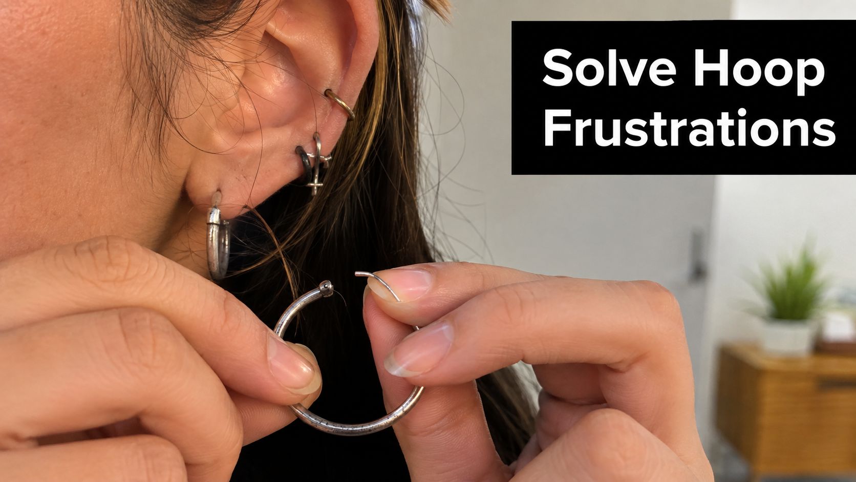 A person holding a silver hoop earring, demonstrating how to open or close the jewelry piece.