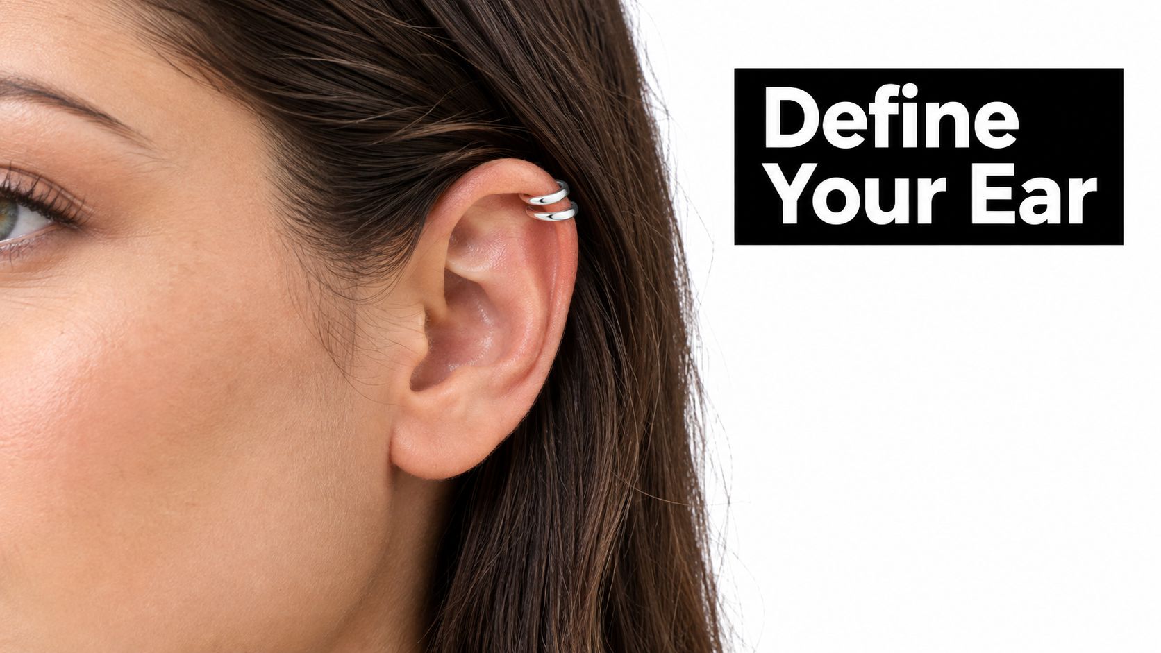 A close-up view of a woman wearing double silver cuff helix piercings on her ear.