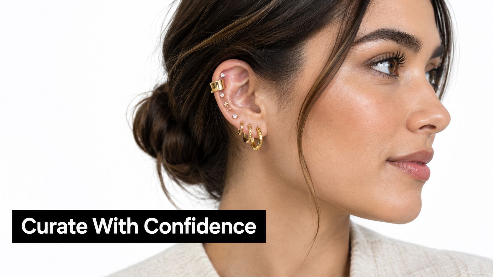 A close-up of a woman's ear adorned with a stylish gold helix piercing, cuff, and hoop earrings.